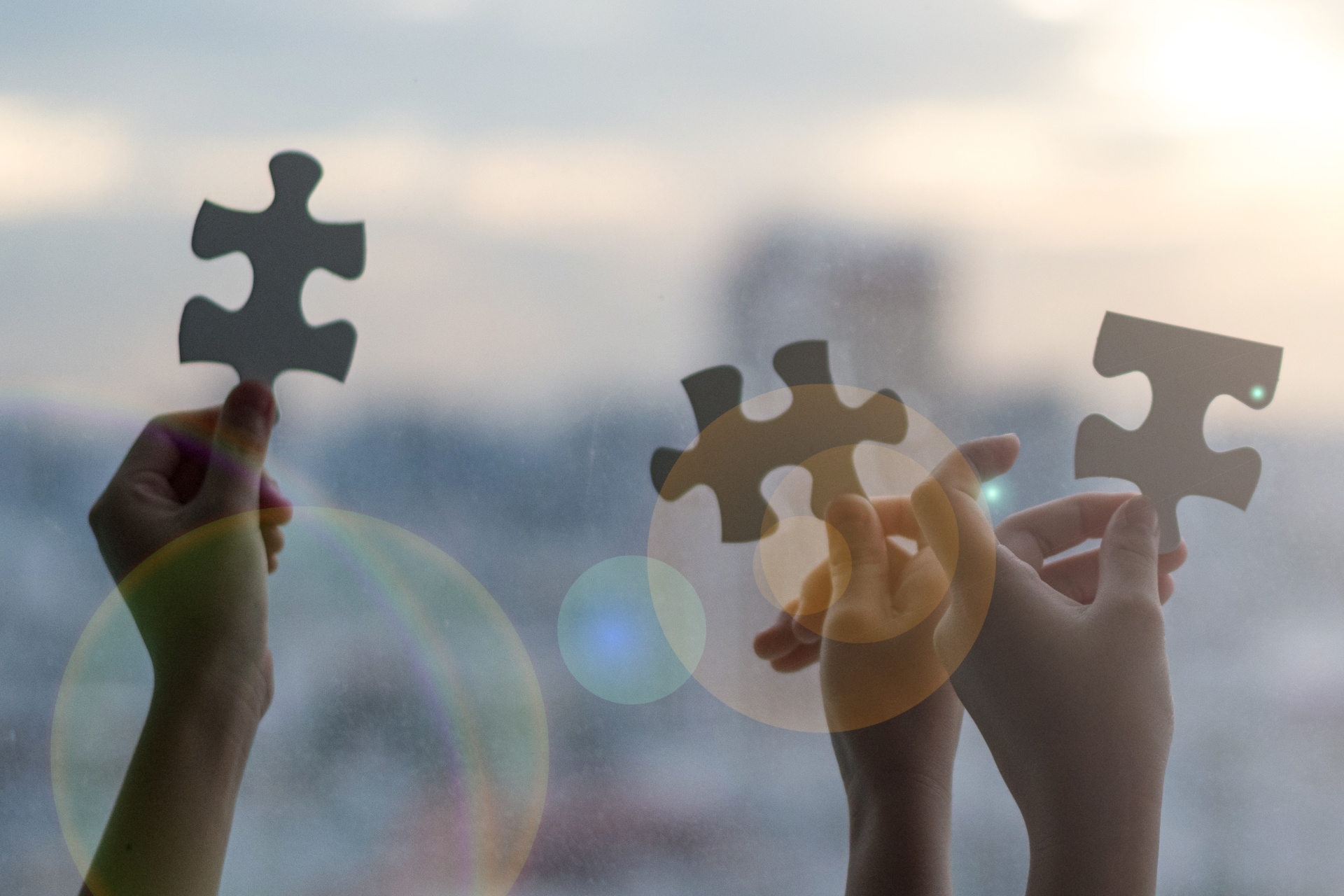 Hands of children students holding pieaces of jiwsaw together as a symbol for autism or teamwork in school.
